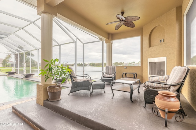 view of patio / terrace with ceiling fan, a water view, and glass enclosure