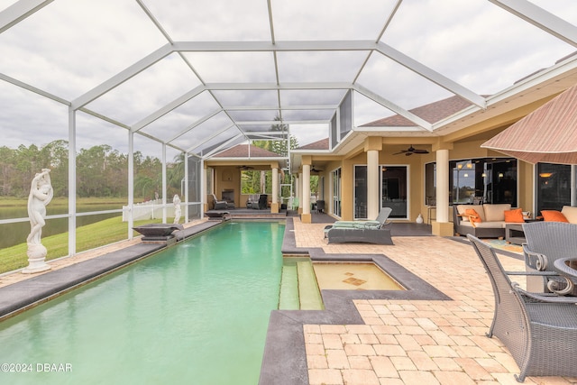 view of pool featuring outdoor lounge area, ceiling fan, a patio, and glass enclosure