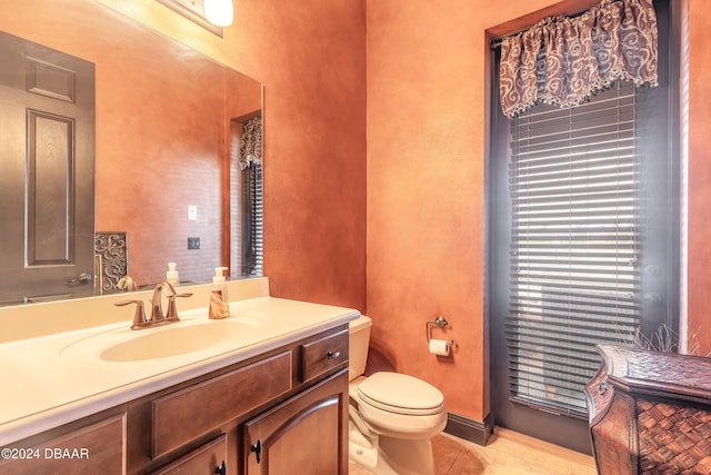 bathroom with tile patterned flooring, vanity, and toilet