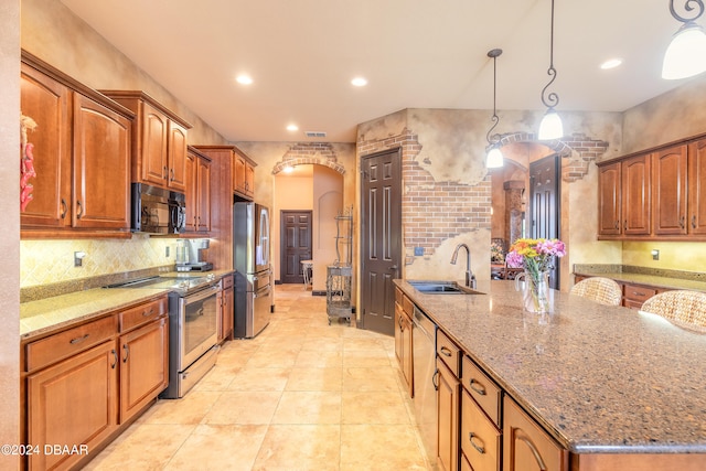 kitchen with sink, light stone counters, decorative light fixtures, light tile patterned floors, and appliances with stainless steel finishes