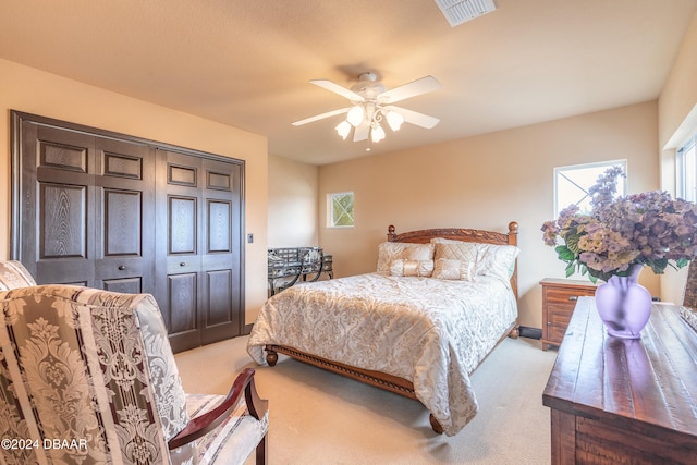 carpeted bedroom featuring ceiling fan and a closet