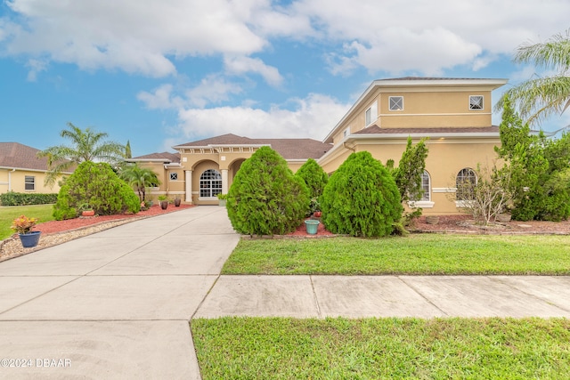 mediterranean / spanish-style house with a front lawn