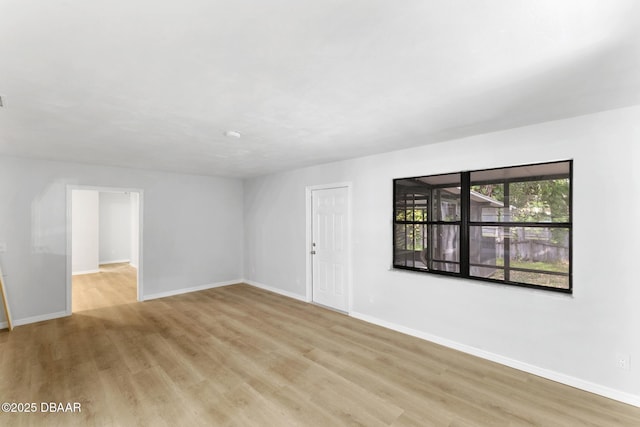 unfurnished living room with baseboards and light wood-style flooring