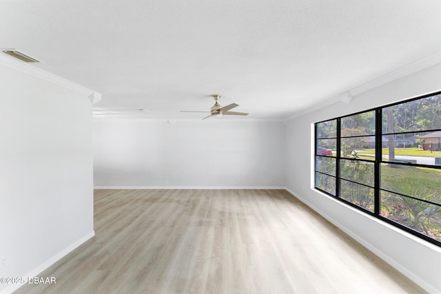spare room featuring visible vents, ornamental molding, baseboards, ceiling fan, and light wood finished floors