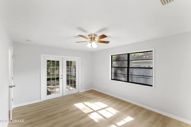 empty room with french doors, baseboards, and plenty of natural light