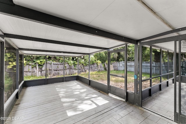 unfurnished sunroom with beam ceiling