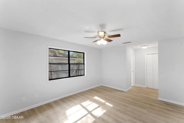 unfurnished room with light wood-style floors, a ceiling fan, baseboards, and visible vents