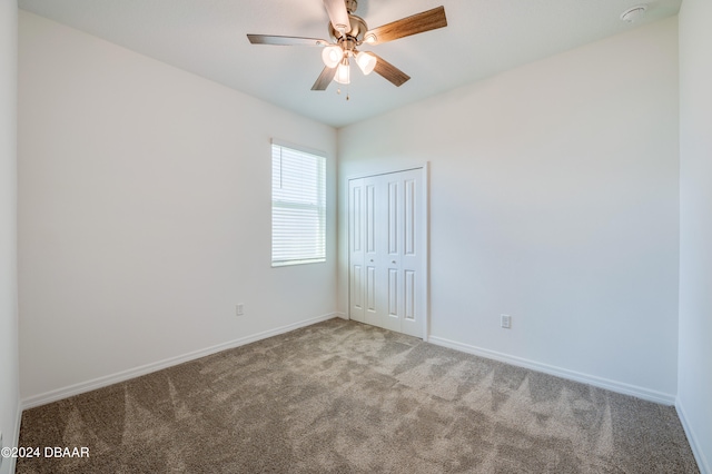 carpeted spare room with ceiling fan