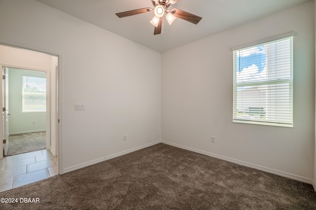 carpeted spare room with ceiling fan