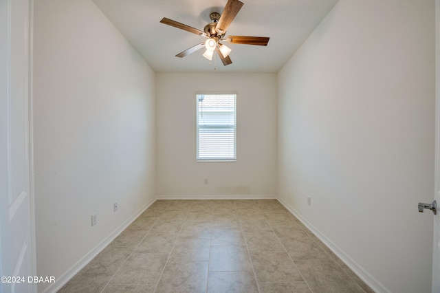 tiled empty room featuring ceiling fan