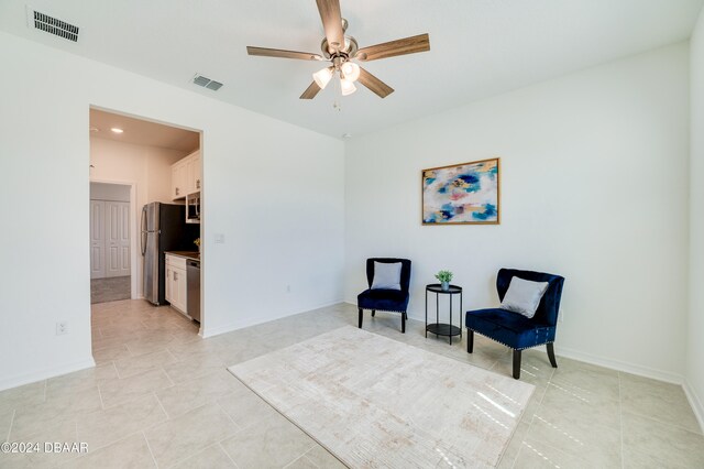 sitting room featuring ceiling fan and light tile patterned floors