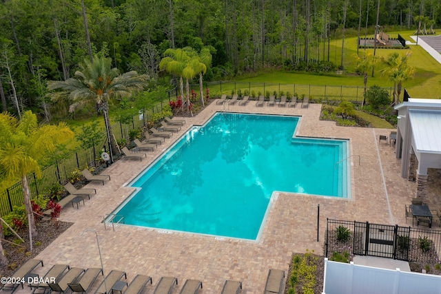 view of pool featuring a lawn and a patio