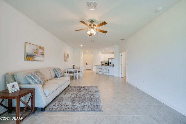 living room with light tile patterned flooring and ceiling fan