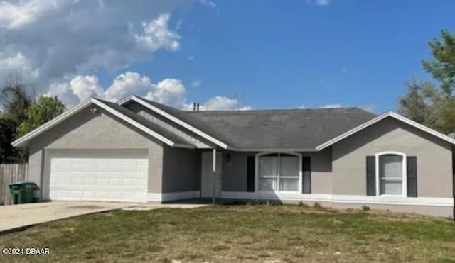 single story home with a garage, concrete driveway, a front lawn, and stucco siding