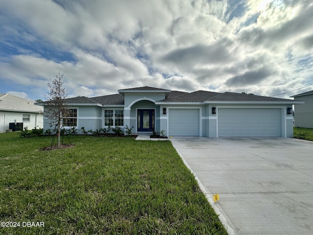 single story home featuring a garage and a front lawn