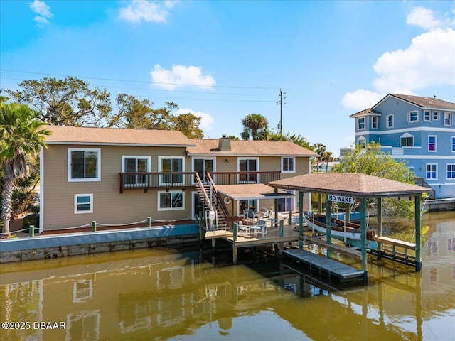 rear view of property with boat lift, a chimney, a deck with water view, and stairs