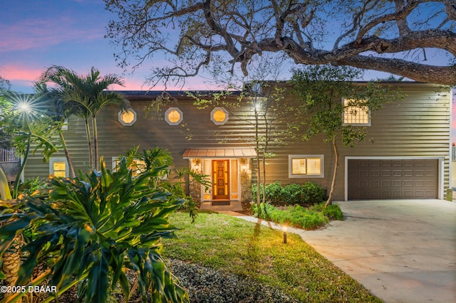 view of front of property featuring concrete driveway and a garage