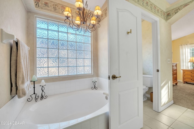 bathroom featuring tile patterned flooring, a notable chandelier, tiled bath, lofted ceiling, and toilet