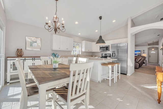 tiled dining area with vaulted ceiling, a notable chandelier, and sink