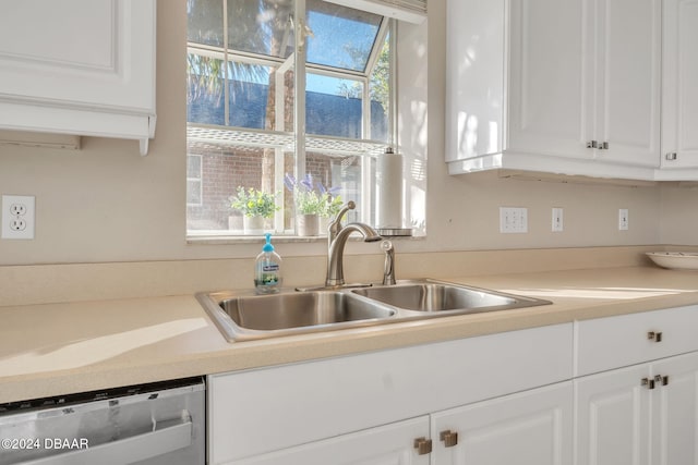 kitchen with dishwasher, white cabinets, and sink