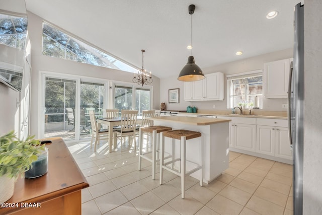 kitchen featuring a center island, white cabinetry, a notable chandelier, and sink