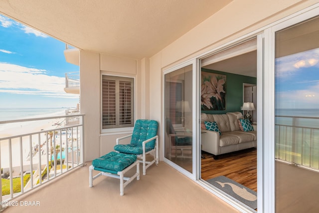 balcony with a water view and a beach view