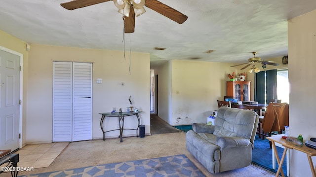 living area with tile patterned flooring and ceiling fan