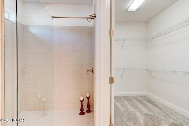 112 Chelsea Place Ave, Ormond Beach, FL 32174 - full bathroom featuring a tile shower, a walk in closet, and baseboards