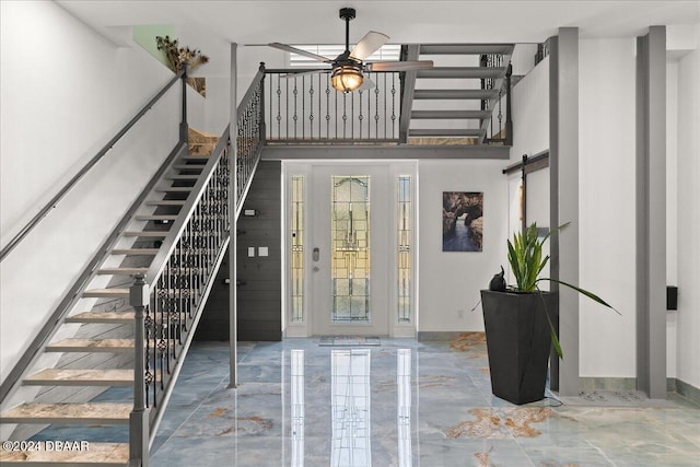 foyer entrance with a barn door and ceiling fan