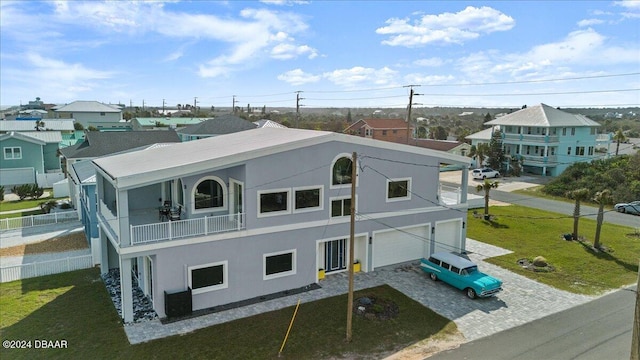 exterior space featuring a lawn, a balcony, and a garage