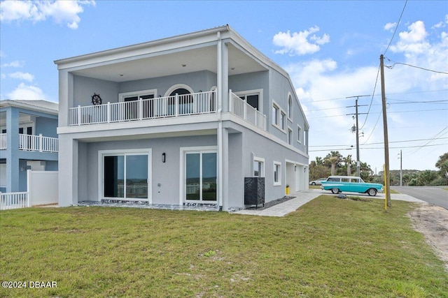 back of house featuring a yard and a balcony