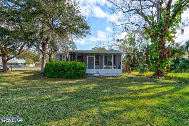 view of front of home featuring a sunroom, fence, and a front yard