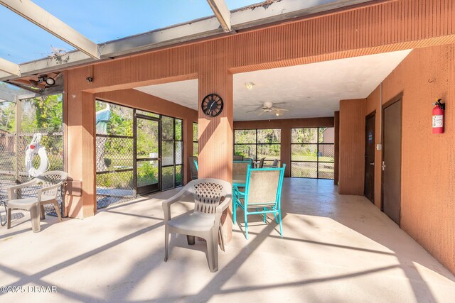 sunroom / solarium featuring a ceiling fan