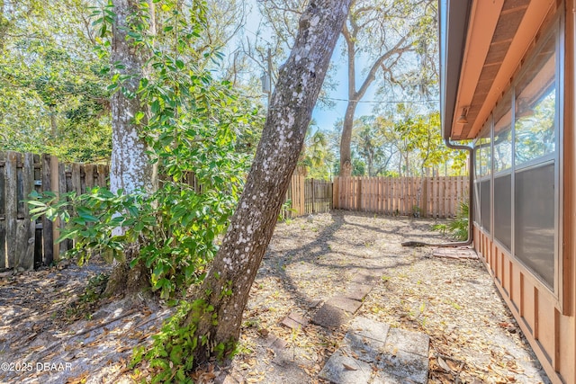 view of yard with a fenced backyard and a sunroom