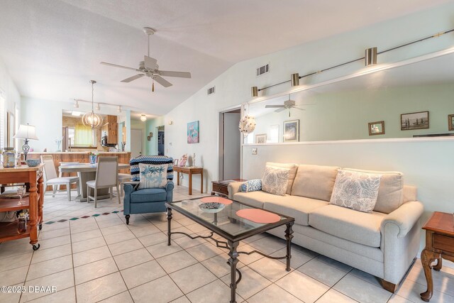 living area with light tile patterned floors, visible vents, lofted ceiling, and a ceiling fan