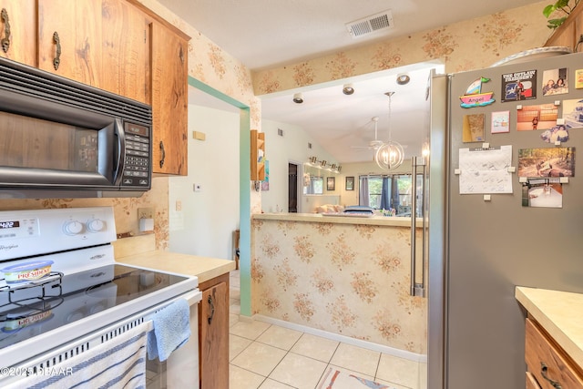 kitchen with visible vents, wallpapered walls, black microwave, freestanding refrigerator, and white electric stove