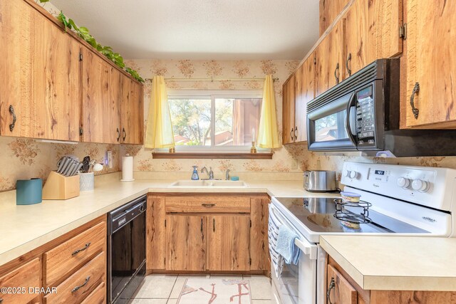 kitchen featuring brown cabinetry, light tile patterned flooring, a sink, black appliances, and light countertops