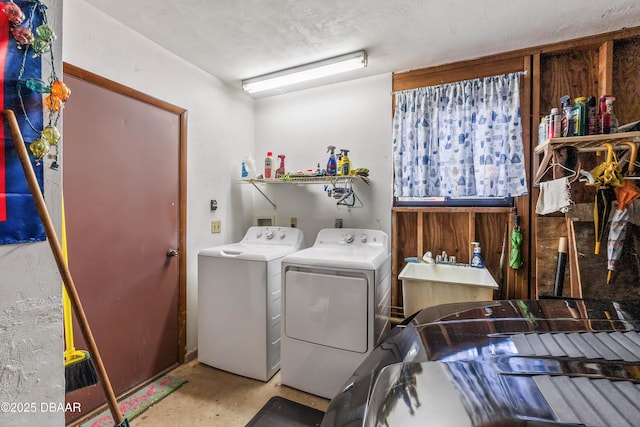 washroom with a sink, a textured ceiling, independent washer and dryer, and laundry area