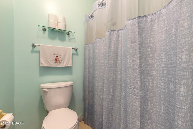 full bath with curtained shower and toilet