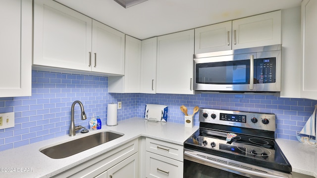 kitchen featuring backsplash, sink, white cabinets, and appliances with stainless steel finishes