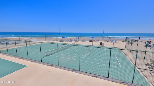 view of sport court with a water view and a view of the beach