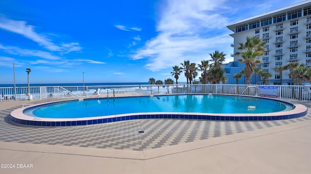 view of pool featuring a patio and a water view