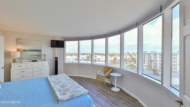 bedroom with wood-type flooring and multiple windows