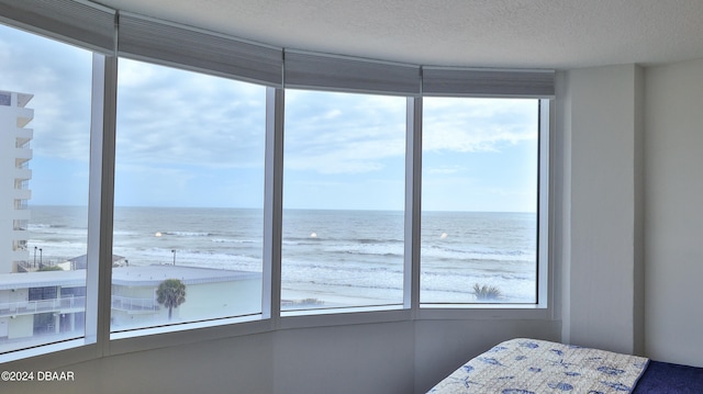 unfurnished bedroom featuring multiple windows and a water view