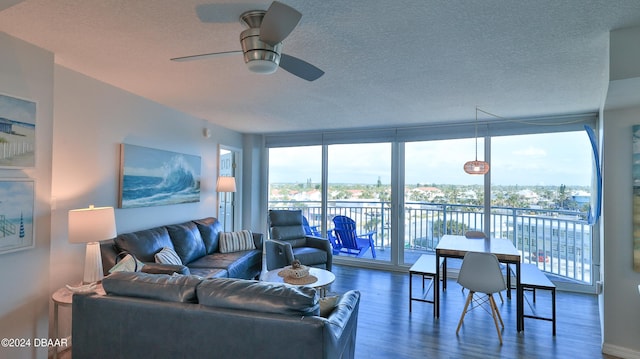 living room featuring floor to ceiling windows, ceiling fan, hardwood / wood-style floors, a textured ceiling, and a water view