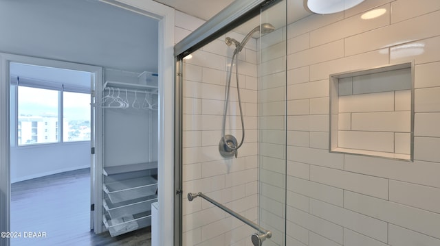 bathroom with hardwood / wood-style floors and an enclosed shower