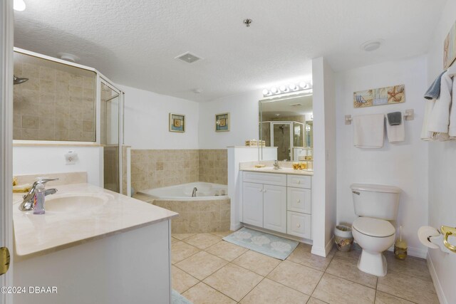 5300 S Atlantic Ave Unit 15-403, New Smyrna Beach, FL 32169 - full bathroom featuring tile patterned floors, a stall shower, two vanities, a garden tub, and a textured ceiling
