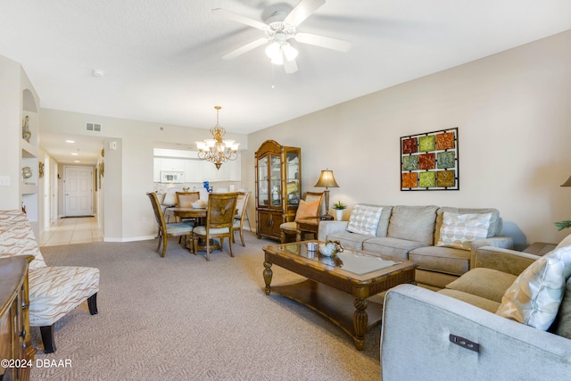 living room with ceiling fan with notable chandelier and light carpet