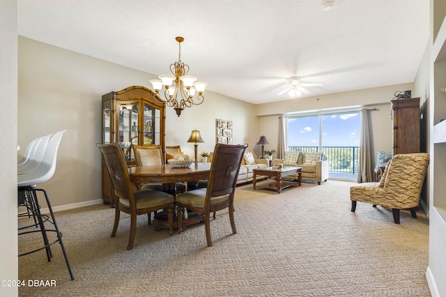 carpeted dining area with ceiling fan with notable chandelier