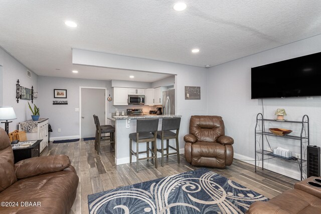 living room featuring dark wood-type flooring and a textured ceiling